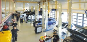Automotive workshop with OMCN vehicle lifts and technicians