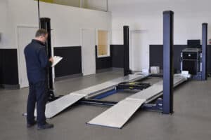 Technician Inspecting a Four-Post Vehicle Lift