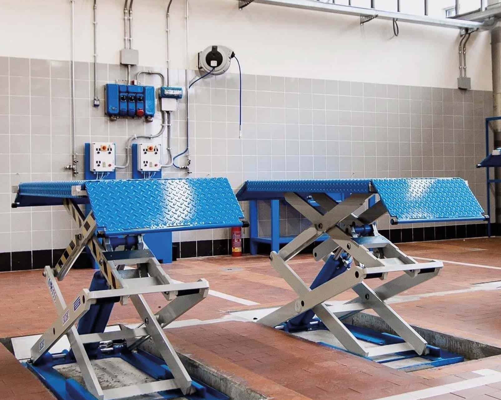 Two OMCN scissor lifts in an automotive workshop